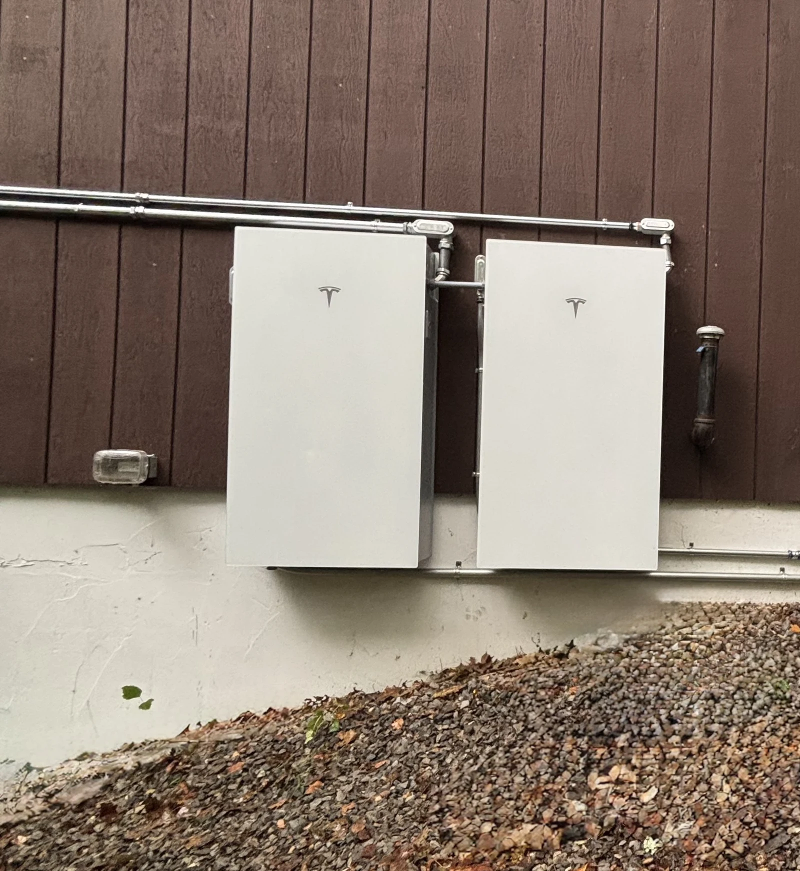 EVCIA exterior installation of wall-mounted Tesla battery equipment