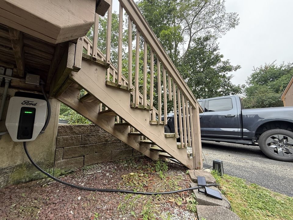 Ford Charge Station Pro installed beside a residence with a Ford electric truck nearby