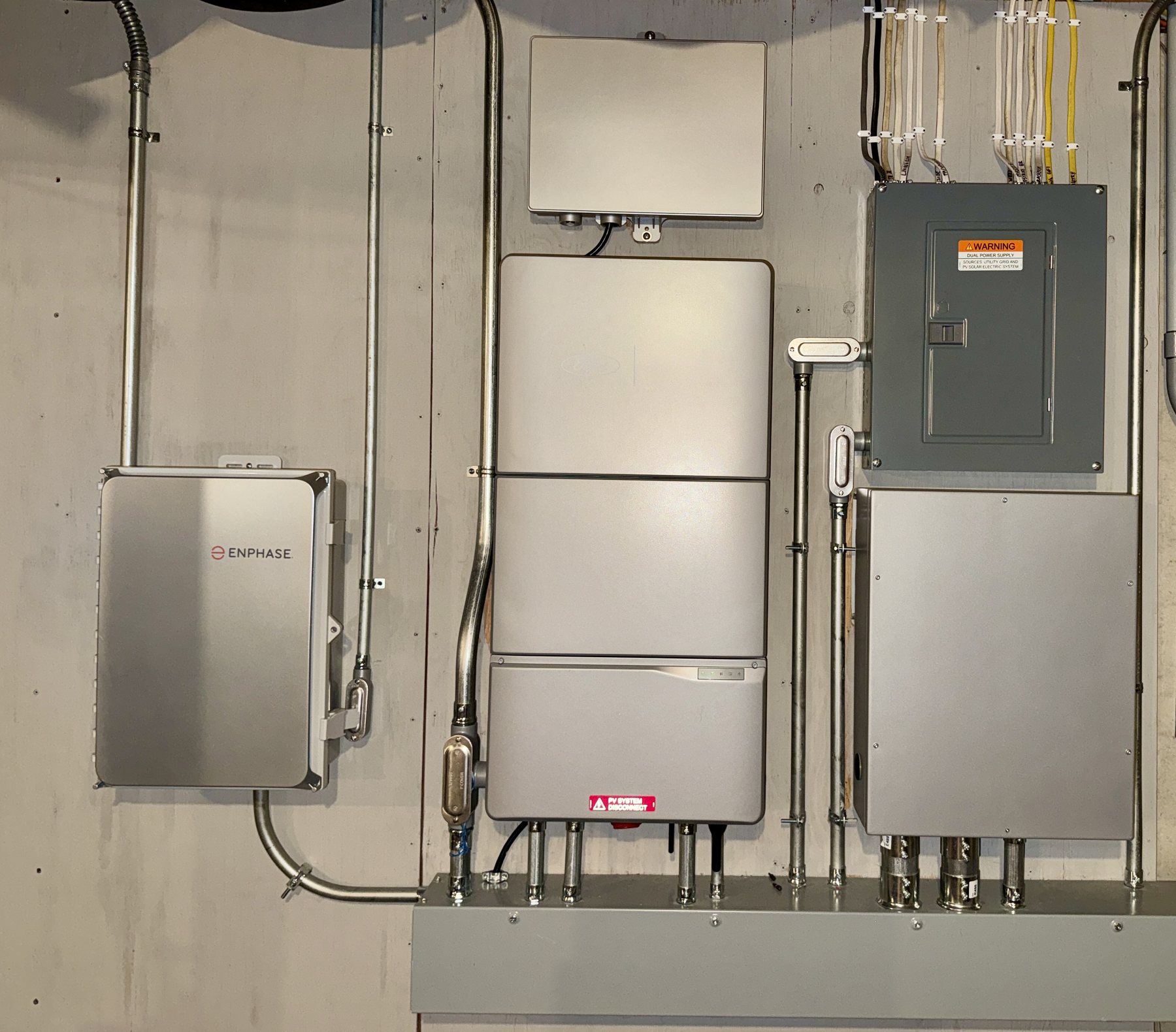 Residential electrical and home-energy integration equipment installed beside existing Enphase solar equipment