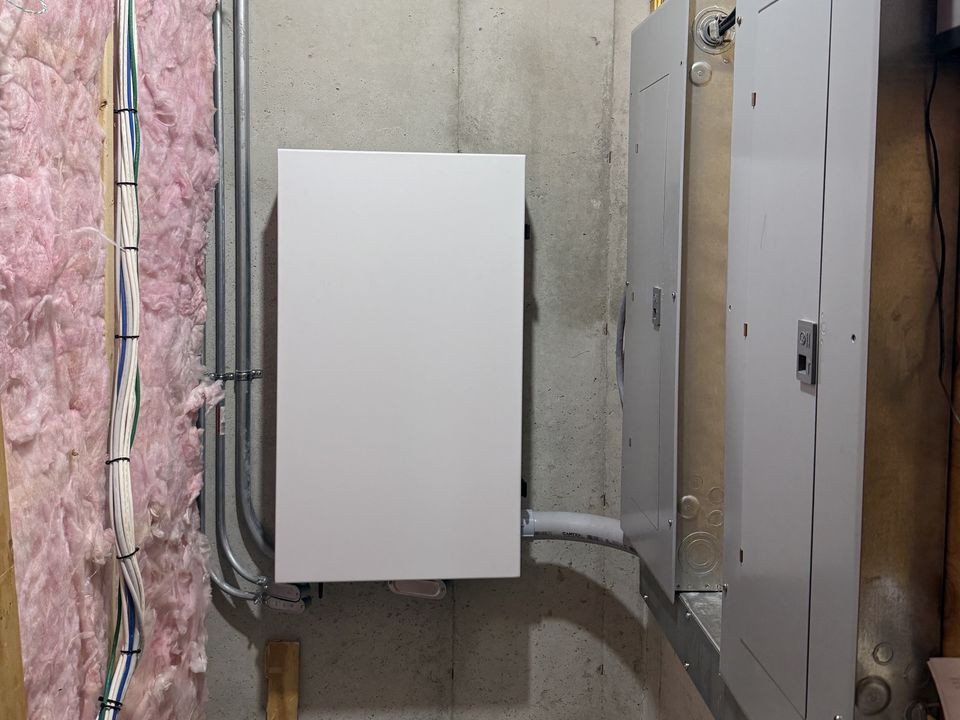 GM Energy V2H equipment installed beside residential electrical service panels